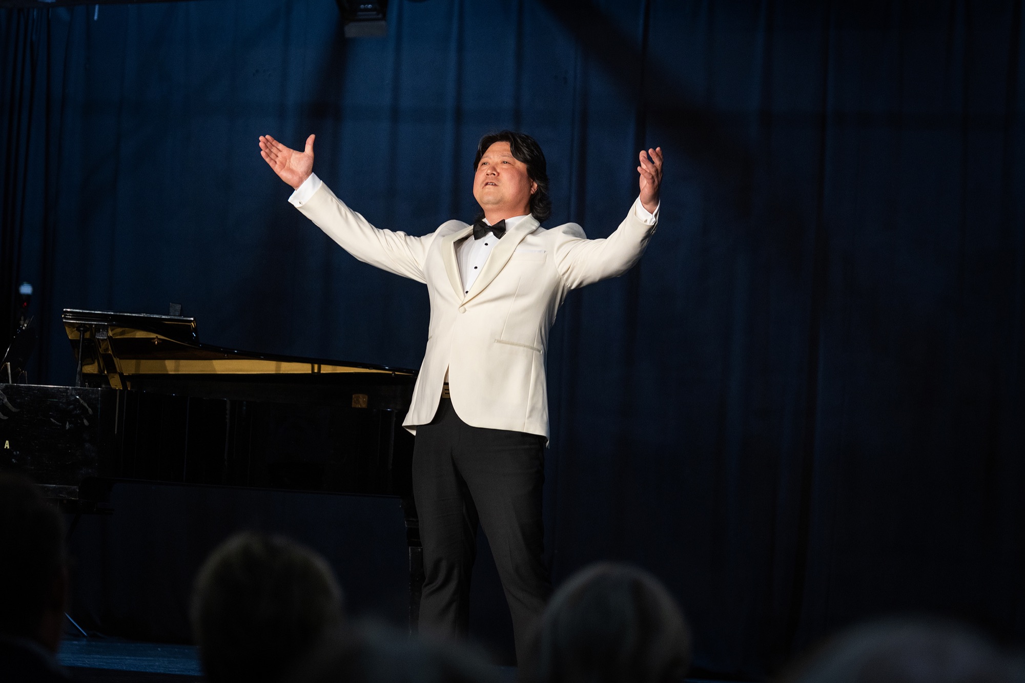 A tenor raises his arms at the close of a performance on the North of Perth Music Festival stage.