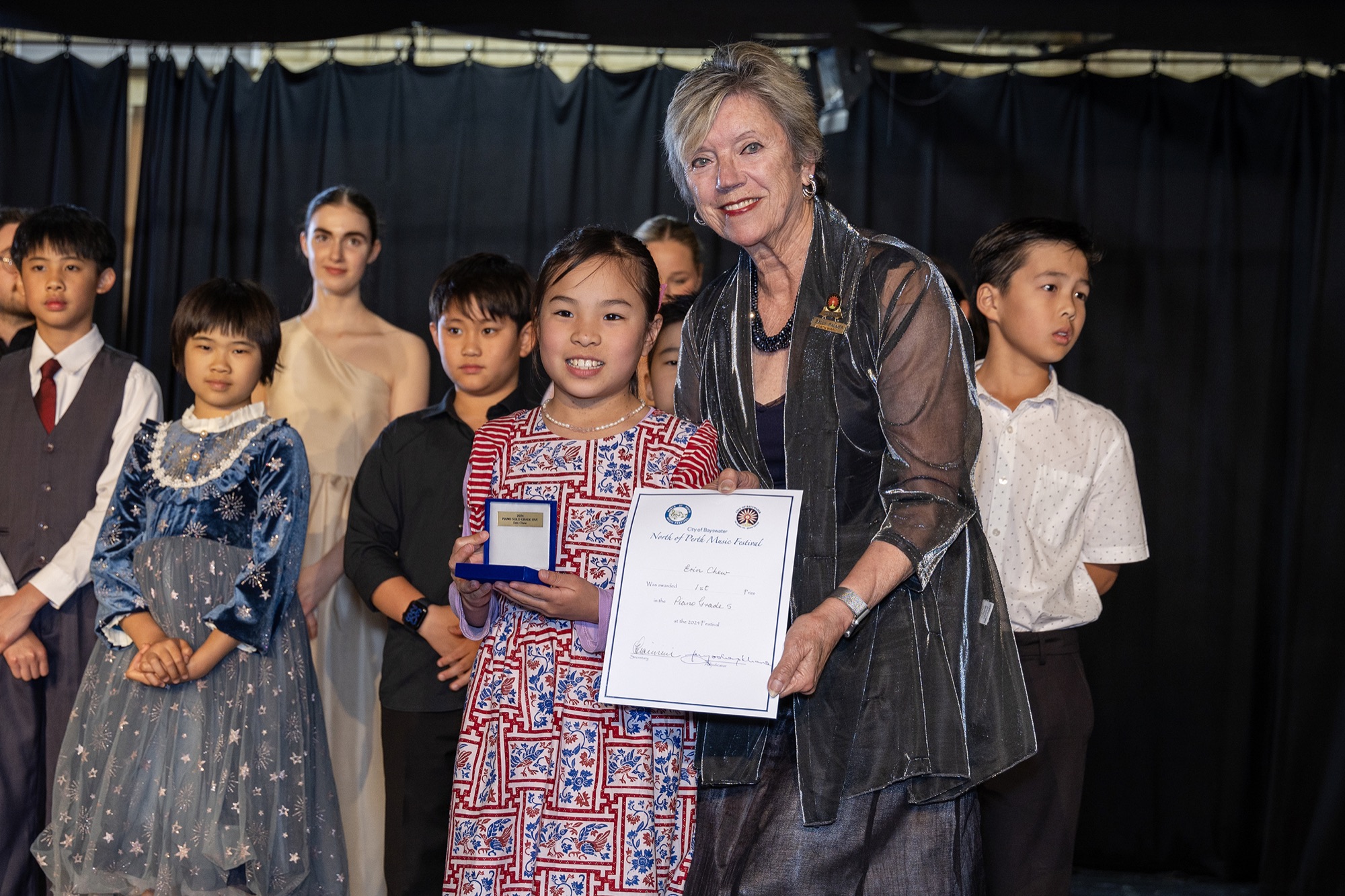A young winner receives her certificate and medallion on stage at the North of Perth Music Festival.