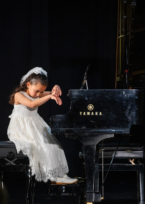 A young pianist takes a bow after her recital.